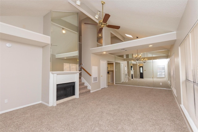 unfurnished living room with carpet flooring, ceiling fan with notable chandelier, a fireplace, and visible vents