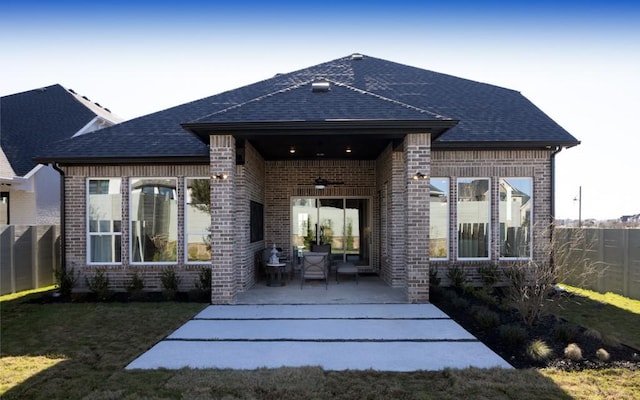 back of property with brick siding, ceiling fan, and fence