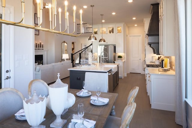 dining room featuring a fireplace, wood finished floors, stairway, and recessed lighting