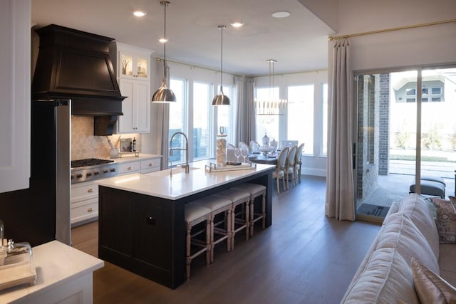 kitchen with glass insert cabinets, light countertops, custom range hood, and dark wood-style flooring