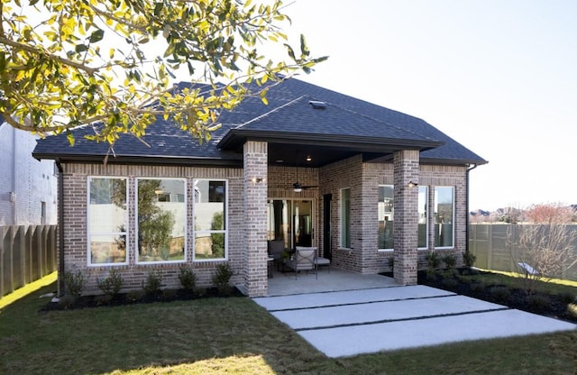 back of property featuring brick siding, a patio area, a lawn, and a fenced backyard