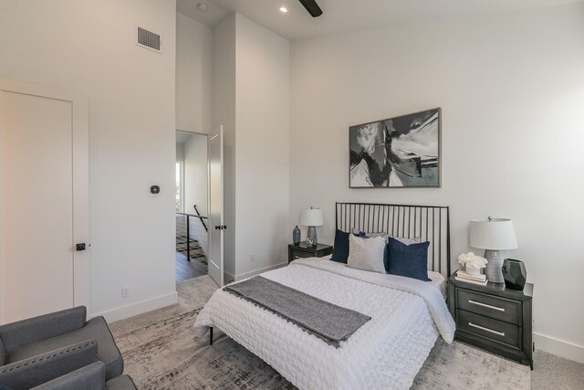 carpeted bedroom with a high ceiling, recessed lighting, baseboards, and visible vents