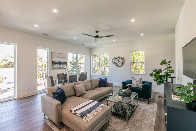 living area with dark wood finished floors, plenty of natural light, recessed lighting, and baseboards