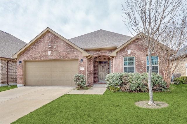 view of front of home with a front lawn, driveway, an attached garage, a shingled roof, and brick siding