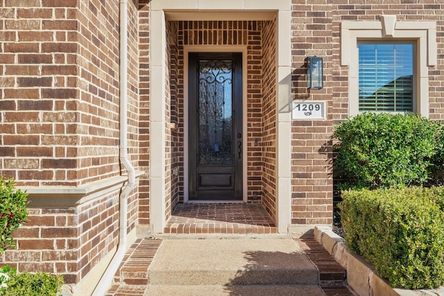 entrance to property featuring brick siding