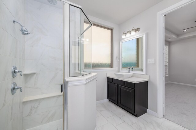 bathroom with vanity, marble finish floor, baseboards, and a marble finish shower