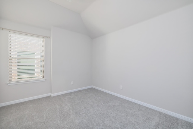 unfurnished room with baseboards, carpet, and vaulted ceiling