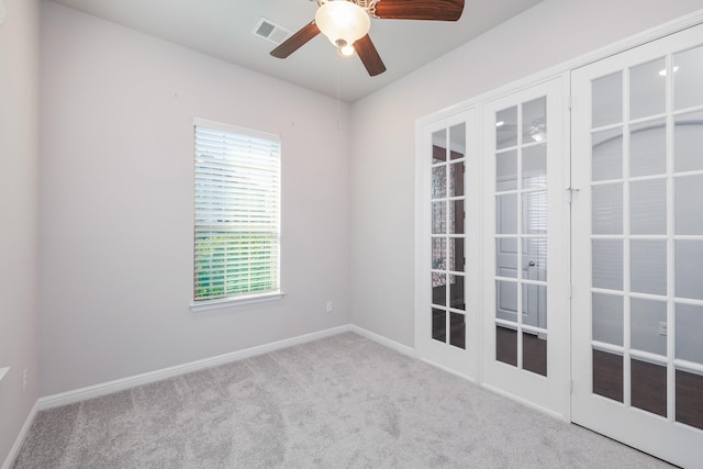 unfurnished room with carpet, visible vents, baseboards, ceiling fan, and french doors