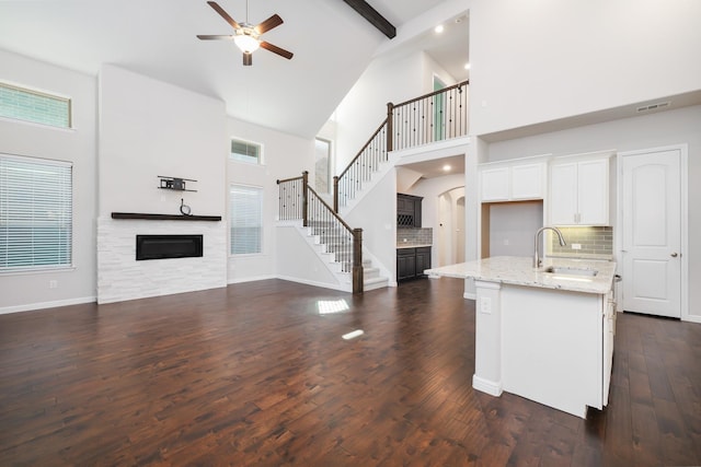 kitchen featuring a sink, visible vents, open floor plan, and a glass covered fireplace