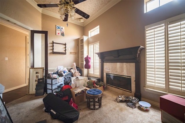 living area featuring crown molding, baseboards, carpet, a fireplace, and a towering ceiling