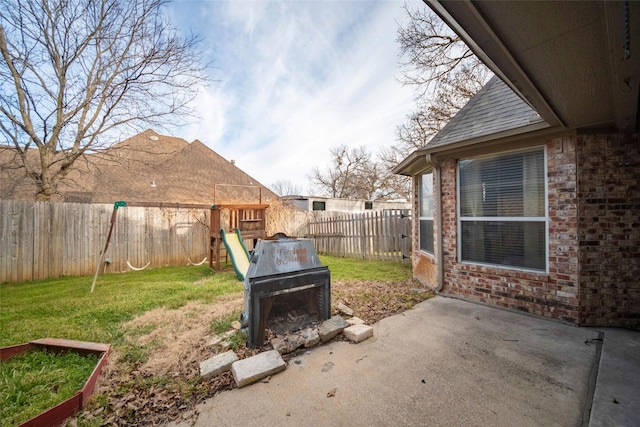 view of yard featuring a patio, a playground, and a fenced backyard