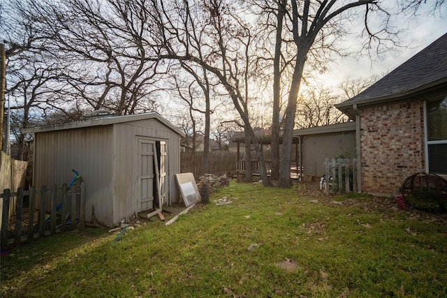 view of yard featuring an outbuilding, fence, and a shed