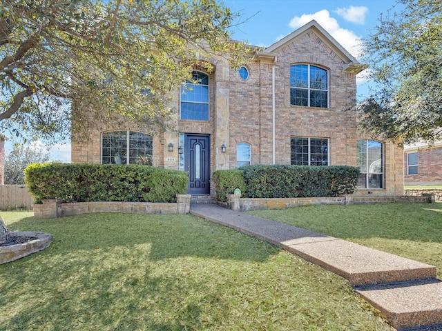 traditional-style house with brick siding and a front lawn