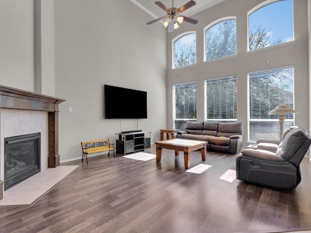 living area featuring a fireplace, wood finished floors, and a ceiling fan