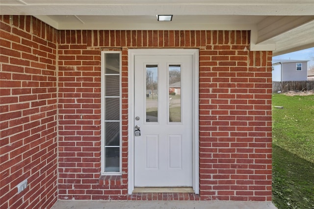 doorway to property featuring brick siding