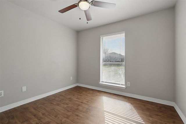 empty room featuring dark wood-style floors, ceiling fan, and baseboards