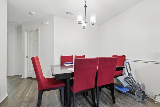 dining area featuring visible vents, baseboards, an inviting chandelier, and wood finished floors