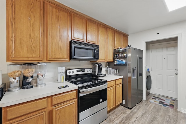 kitchen featuring light wood-type flooring, washer / clothes dryer, stainless steel appliances, light countertops, and brown cabinets