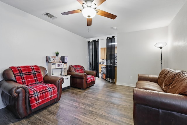 living room with a ceiling fan, wood finished floors, visible vents, and baseboards