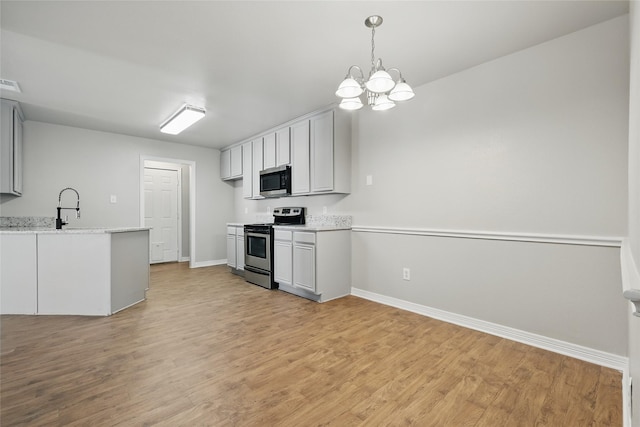 kitchen featuring visible vents, light wood-type flooring, appliances with stainless steel finishes, a notable chandelier, and a sink