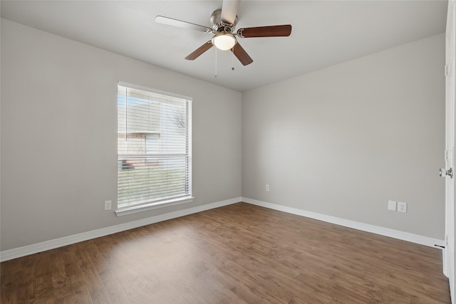 empty room with a ceiling fan, wood finished floors, and baseboards