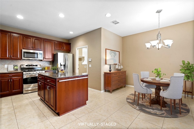 kitchen featuring tasteful backsplash, visible vents, a kitchen island, a chandelier, and stainless steel appliances