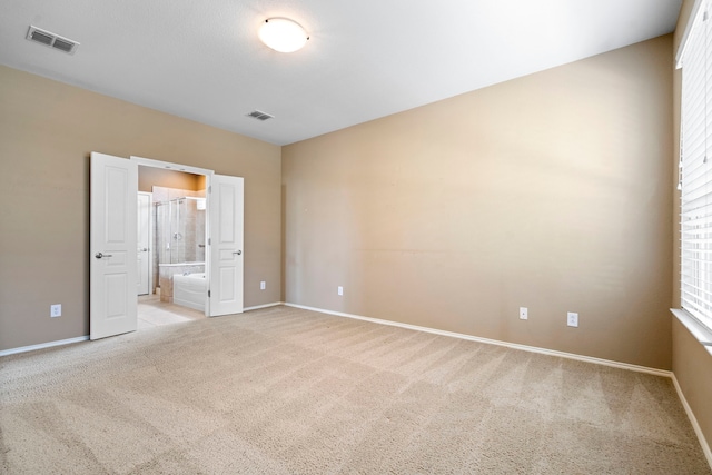 unfurnished room featuring baseboards, visible vents, and light carpet