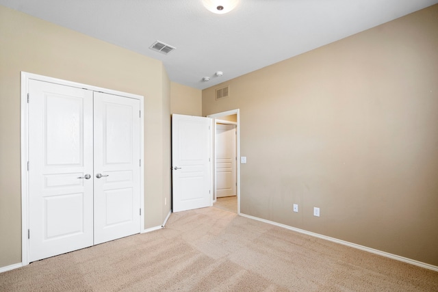 unfurnished bedroom featuring carpet, visible vents, and a closet