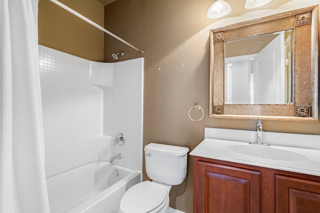 bathroom with a textured wall, vanity, shower / tub combo, and toilet