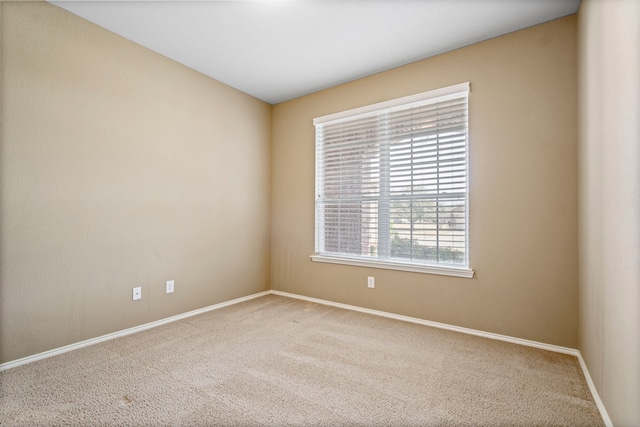 spare room featuring carpet flooring and baseboards