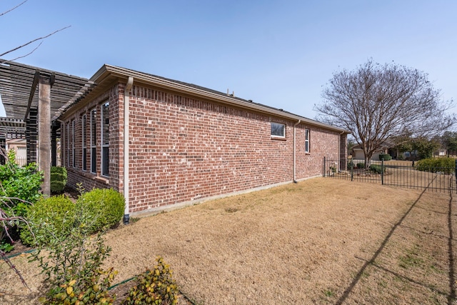 view of home's exterior featuring brick siding and fence