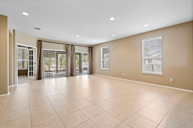 empty room featuring light tile patterned floors, visible vents, recessed lighting, and baseboards