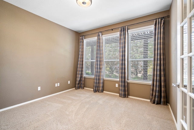 carpeted empty room with baseboards