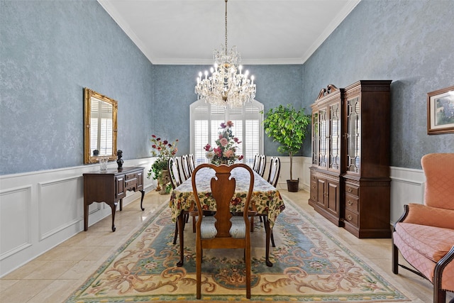 dining area with a notable chandelier, ornamental molding, and wainscoting