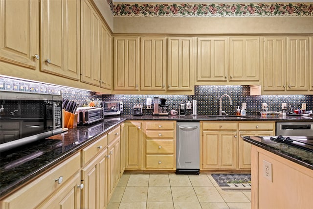 kitchen featuring light brown cabinets, a sink, stainless steel microwave, tasteful backsplash, and light tile patterned flooring