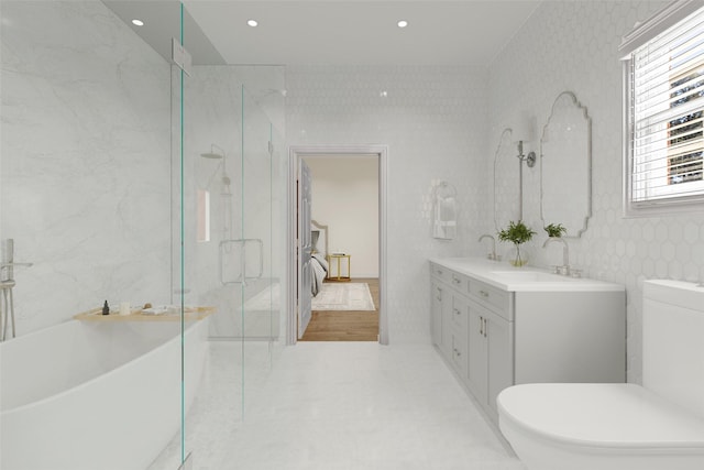 full bathroom with a sink, a marble finish shower, double vanity, and a freestanding tub