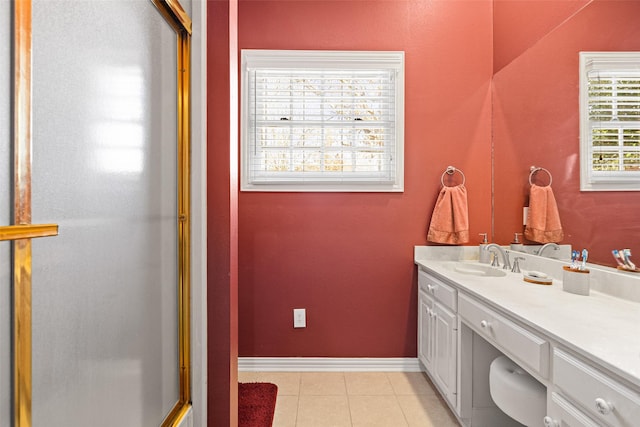 bathroom featuring baseboards, a shower stall, vanity, and tile patterned flooring