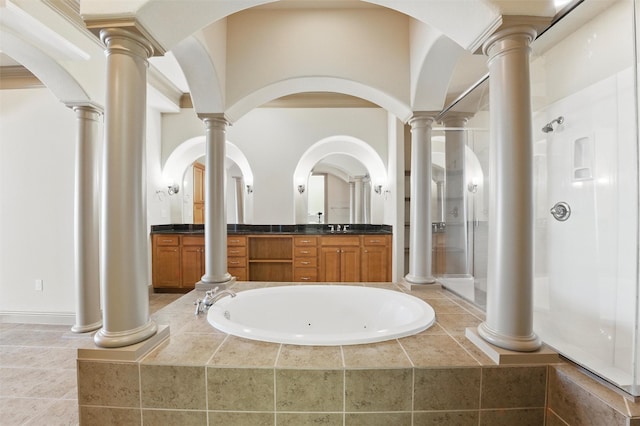 full bathroom featuring a garden tub, a stall shower, vanity, and ornate columns