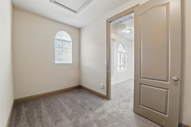 spare room with baseboards, visible vents, attic access, and carpet