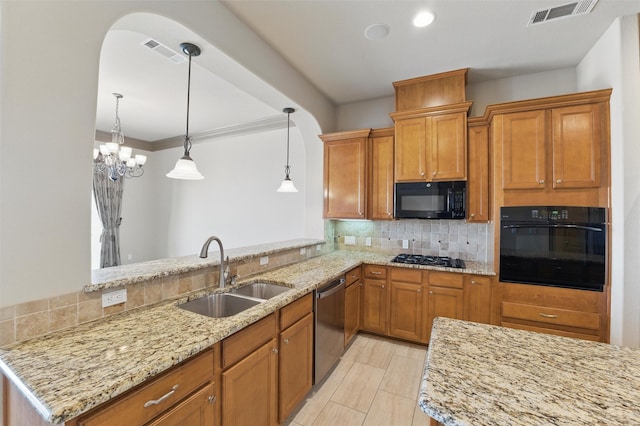 kitchen with visible vents, black appliances, decorative backsplash, and a sink