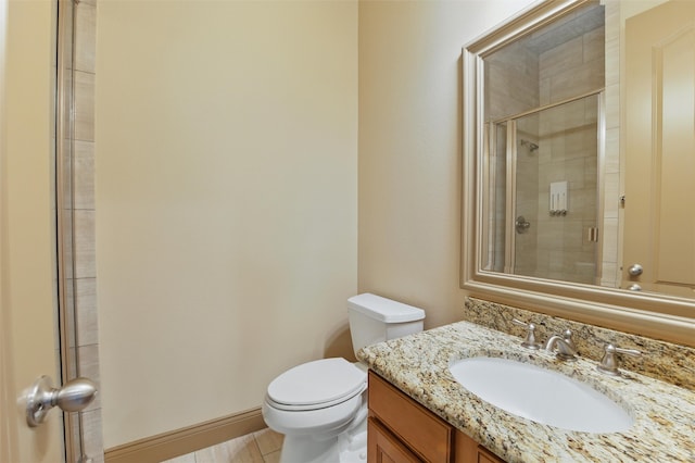 bathroom featuring baseboards, vanity, toilet, and a shower stall