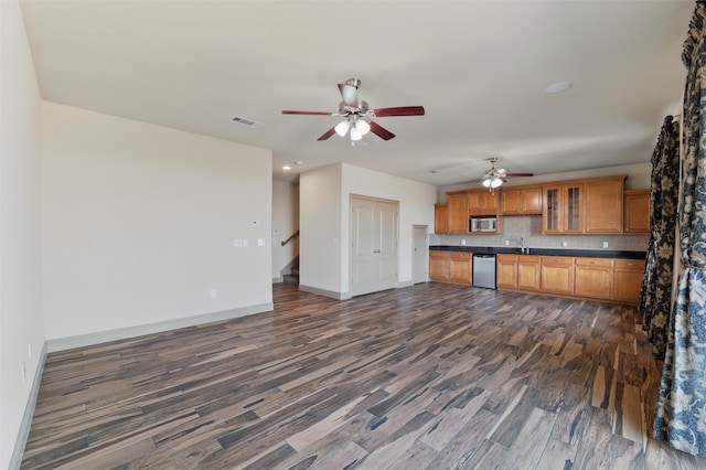 kitchen featuring dark countertops, visible vents, tasteful backsplash, dark wood finished floors, and stainless steel appliances