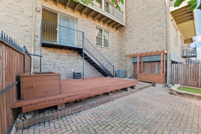 exterior space with a patio area, central AC unit, stairs, and fence