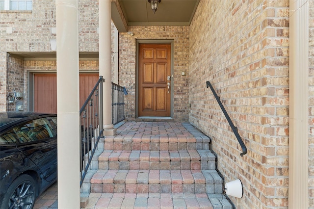 view of exterior entry featuring brick siding