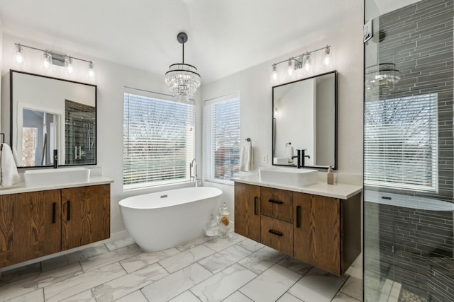 bathroom with a sink, a freestanding bath, and marble finish floor