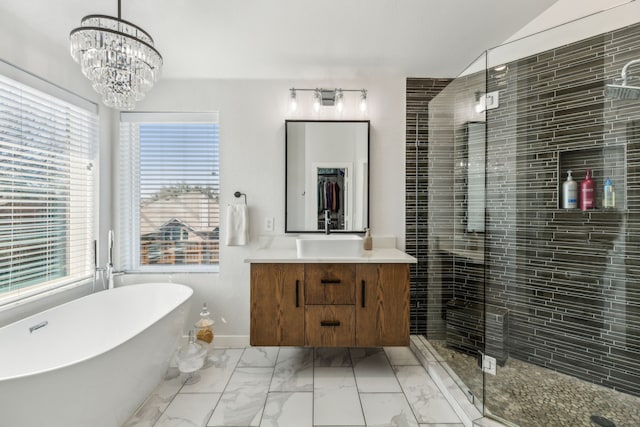 full bathroom with vanity, a freestanding tub, a stall shower, a notable chandelier, and marble finish floor