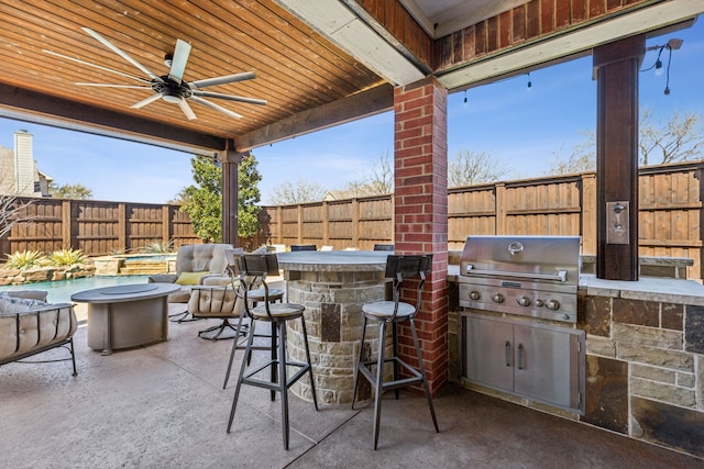 view of patio featuring area for grilling, outdoor dry bar, a fenced backyard, a grill, and ceiling fan