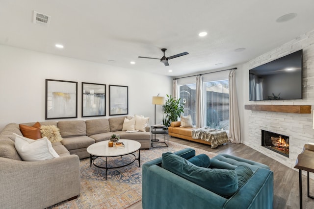 living area featuring visible vents, wood finished floors, recessed lighting, a stone fireplace, and ceiling fan