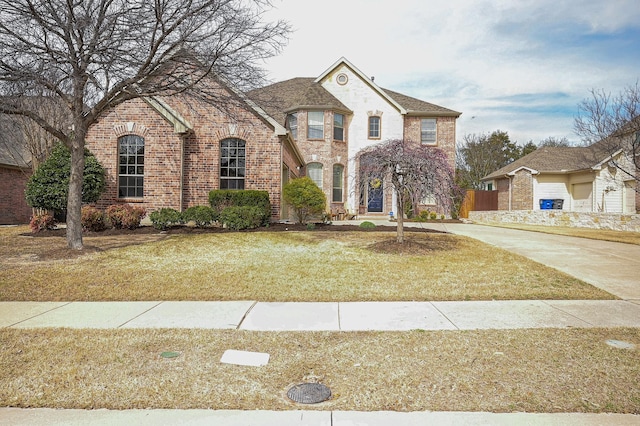 view of front of home with brick siding, driveway, and a front lawn