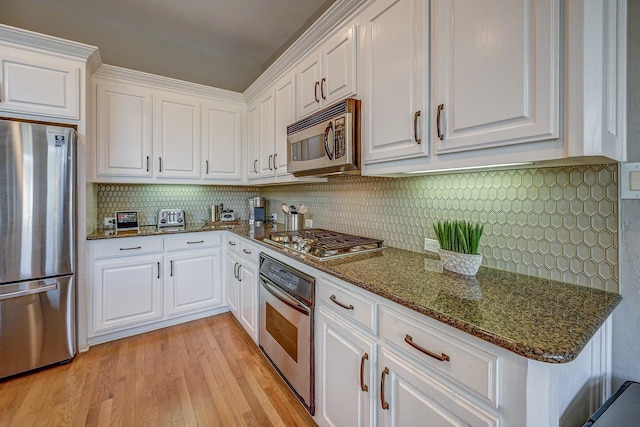 kitchen with stainless steel appliances, light wood finished floors, and white cabinetry